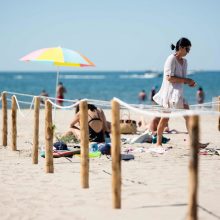 Prancūzai saule mėgaujasi rūpestingai sužymėtuose paplūdimio ploteliuose
