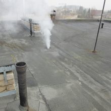 Dūmai iš pastato lietaus nuotekų sistemos parodo jos prijungimą prie buitinių nuotekų tinklo.