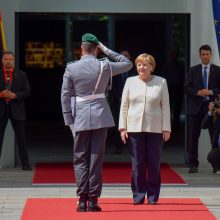 Po drebulio priepuolių A. Merkel skambant himnams liko sėdėti