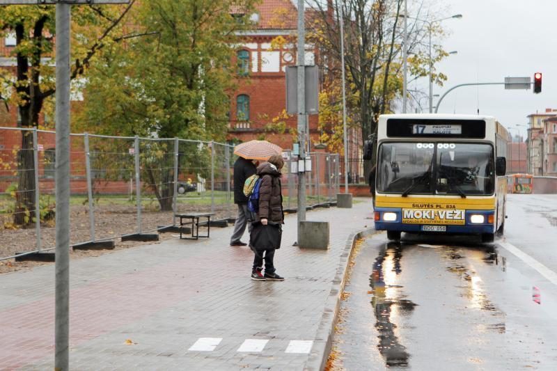 Uostamiesčio gyventojai autobusų laukia prisidengę skėčiais