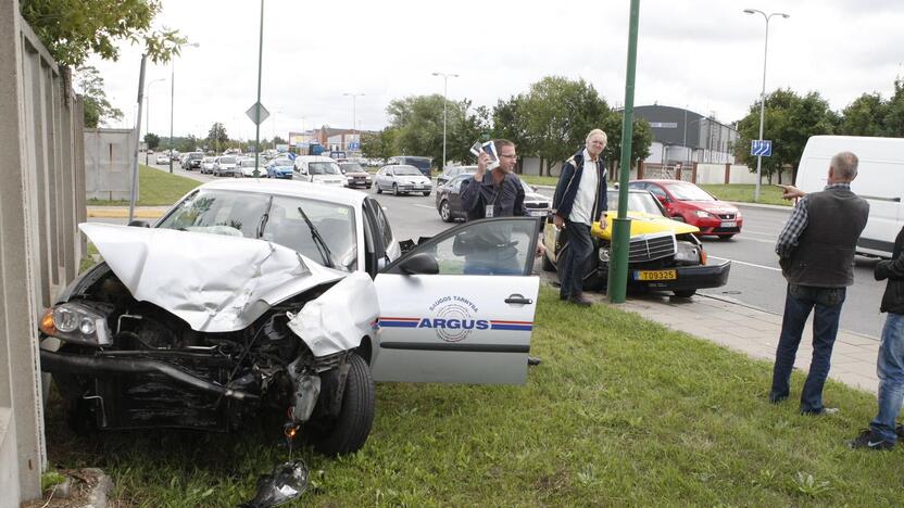 Smūgis: šioje vietoje taksi automobilis mėgino prašokti keturias eismo juostas ir trenkėsi į apsaugininkų automobilį, jį priplodamas prie betoninės tvoros.