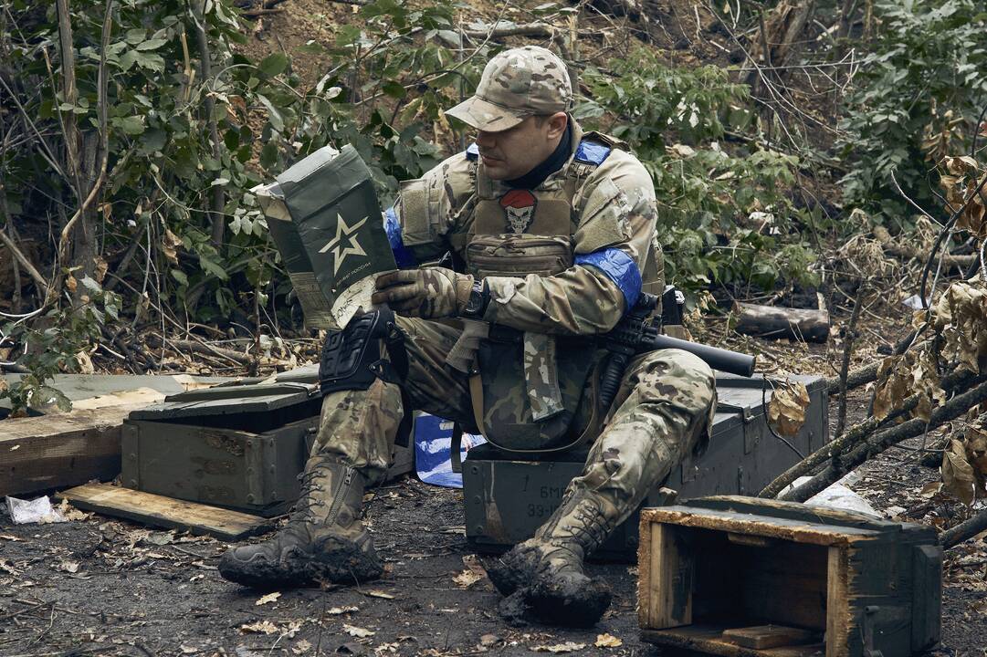 Skirtumai: Ukrainos karys tyrinėja maisto davinio, kuriuo maitinosi dabar jau išvaduotą Kupianską kontroliavę Rusijos kariai.