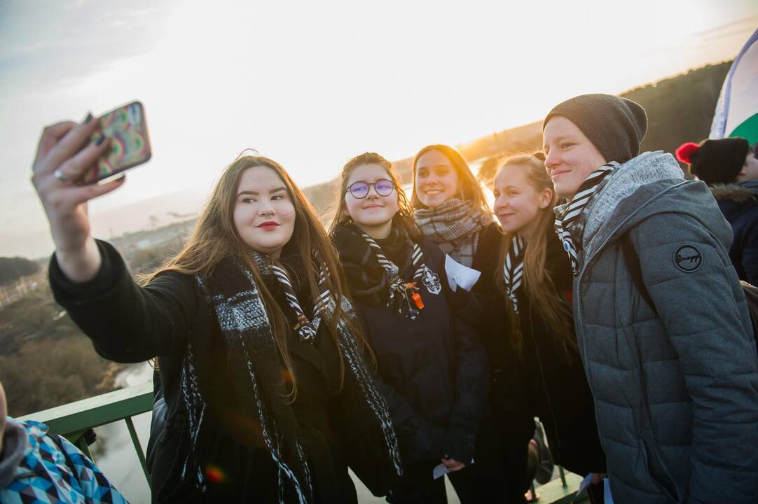 Proga: Kauno skautai šeštadienio rytą savo organizacijos įkūrėjo gimtadienį šventė pasitikdami saulę ant pėsčiųjų tilto į Panemunės šilą.