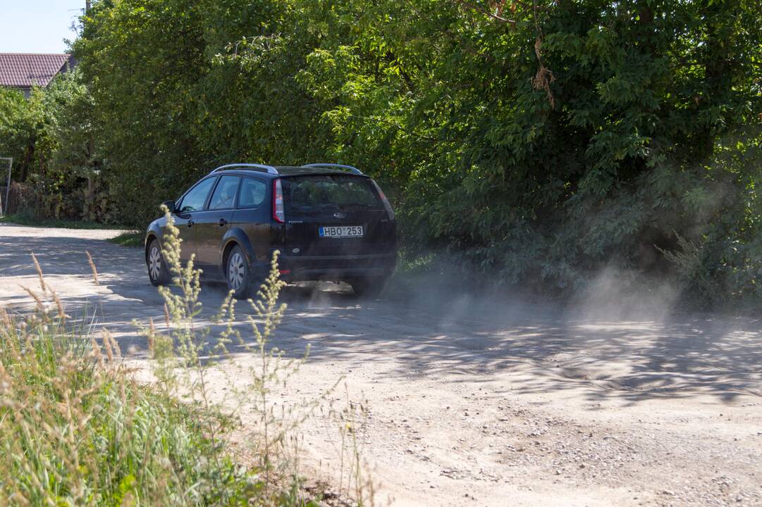 Kenčia: pravažiuojantys automobiliai nuolat kelia dulkių debesis.