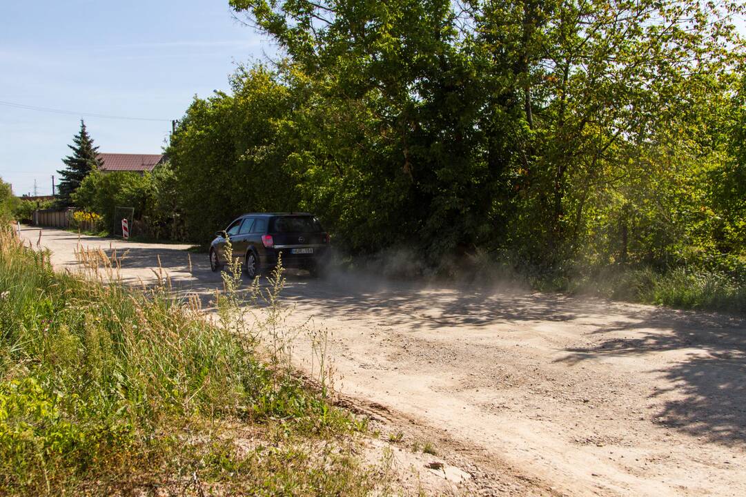Kenčia: pravažiuojantys automobiliai nuolat kelia dulkių debesis.