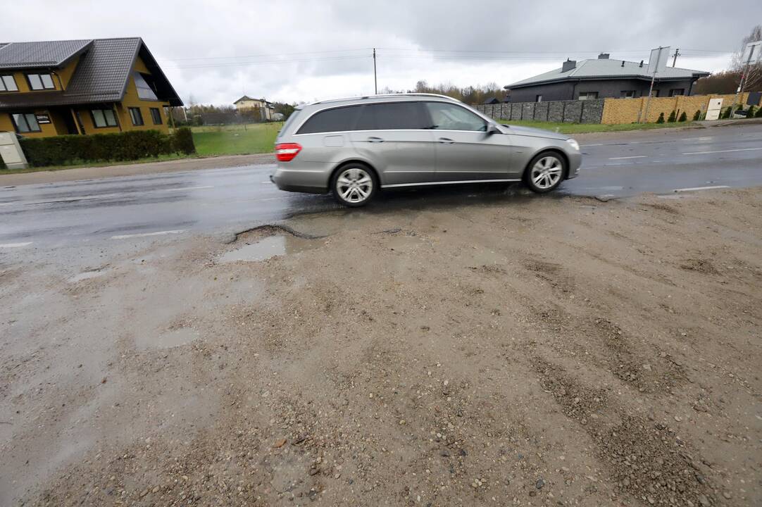 Problema: gyventojai į namus priversti važiuoti duobėtu žvyro keliu.