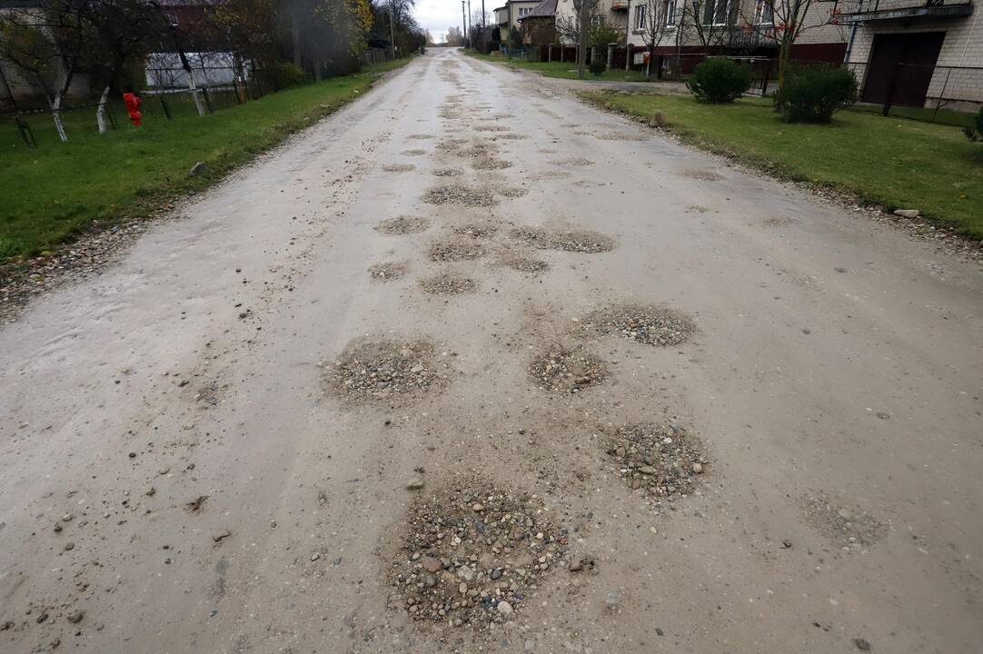 Problema: gyventojai į namus priversti važiuoti duobėtu žvyro keliu.