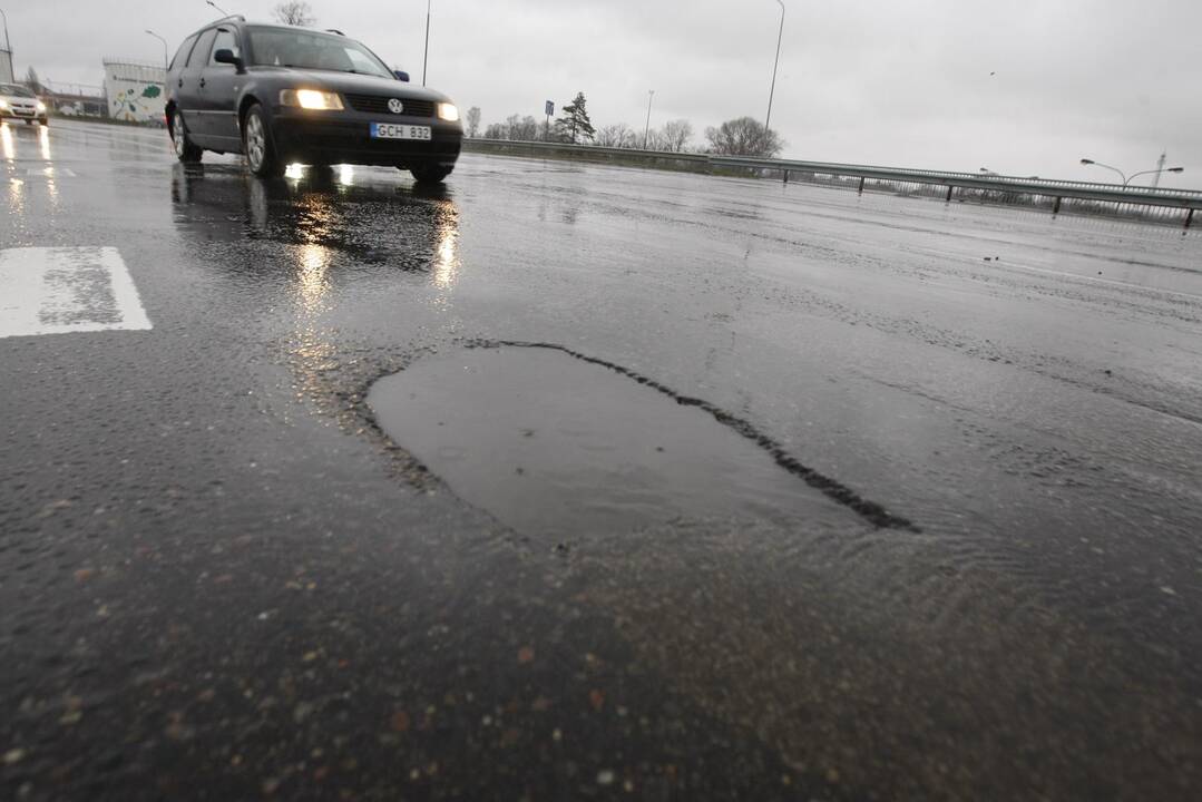 Nuostoliai: dėl gatvėse susidariusių kelio įlūžų kasdien niokojami vairuotojų automobiliai.