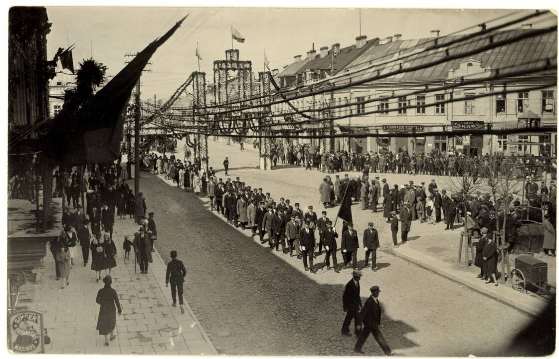 Valstybinės šventės dalyviai eina pro garbės vartus Laisvės alėjoje. Kaunas, apie 1928 m.