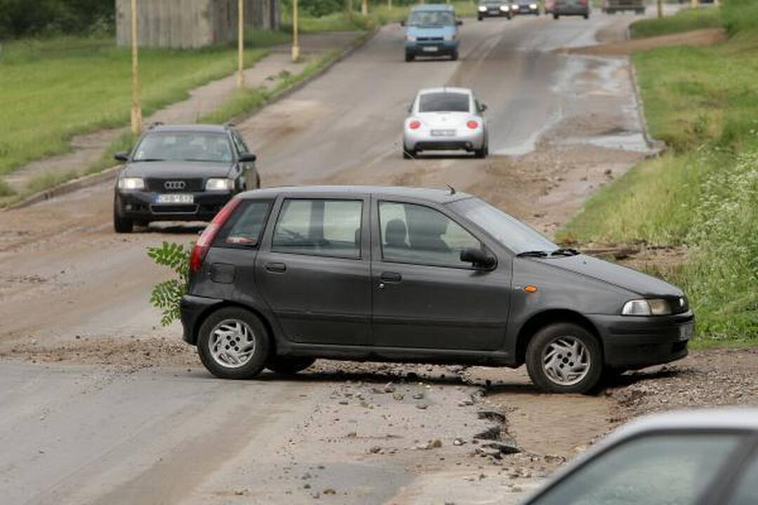 Lietus išardė asfaltą nuovažoje nuo tilto per Nerį