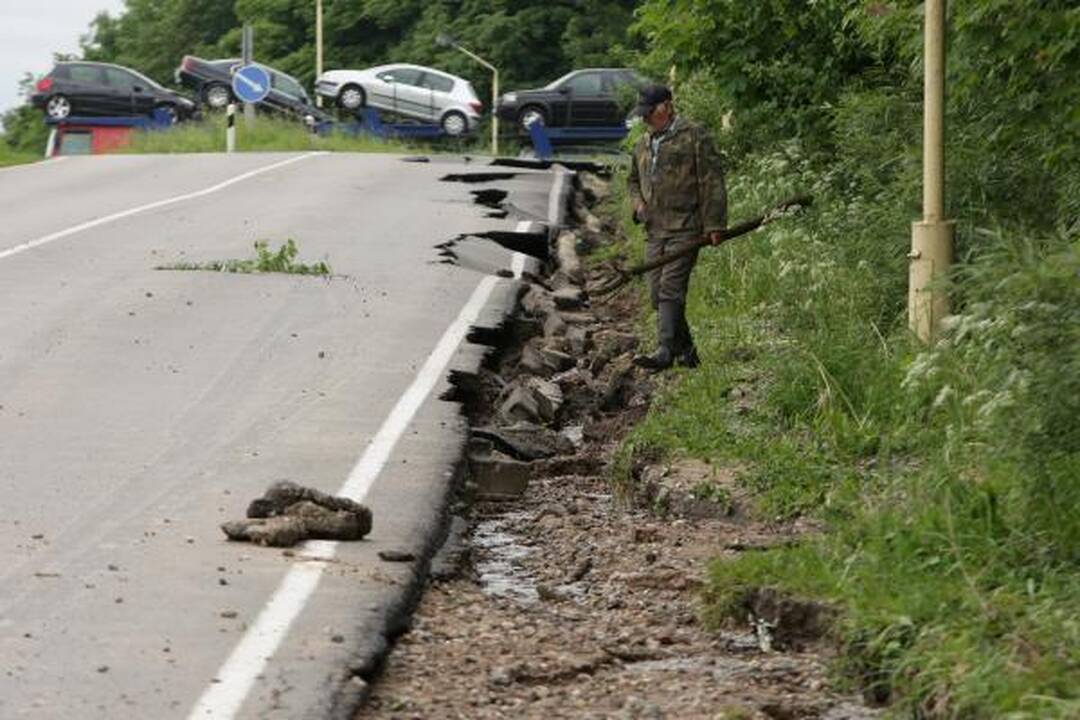 Lietus išardė asfaltą nuovažoje nuo tilto per Nerį