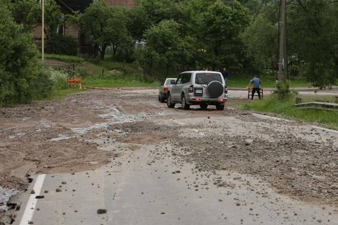 Lietus išardė asfaltą nuovažoje nuo tilto per Nerį