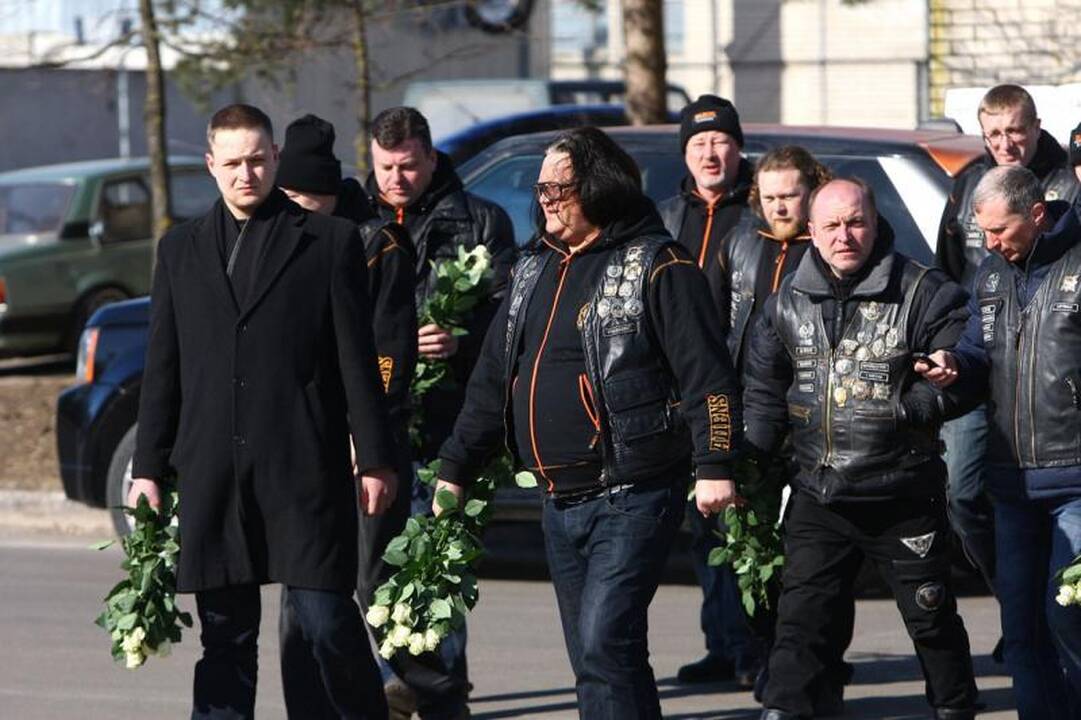 Su I.Matijošaitiene atsisveikinantys žmonės neša baltas gėles 