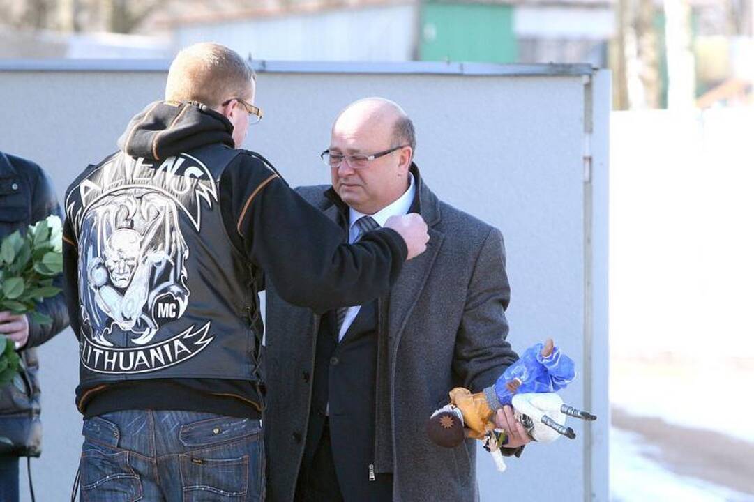 Su I.Matijošaitiene atsisveikinantys žmonės neša baltas gėles 