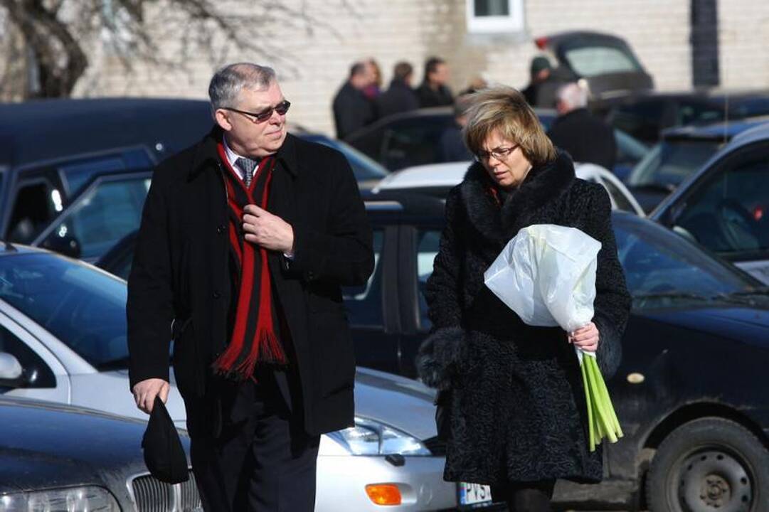 Su I.Matijošaitiene atsisveikinantys žmonės neša baltas gėles 