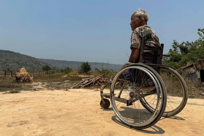 Budelis: Pol Poto režimo liudininkas ir dalyvis buvęs Raudonasis khmeras Phong Heangas sėdi neįgaliojo vežimėlyje savo namuose Anlong Veng rajone Oddar Meanchey provincijoje, 2025 m. kovas.
