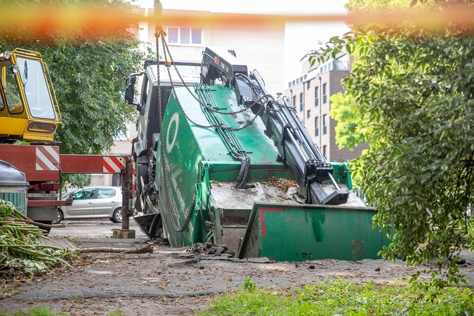 Neįprastas vaizdas: Kauno centre įlūžus asfaltui į duobę įkrito šiukšliavežis