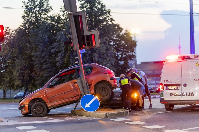 Vilniuje „Peugeot“ susidūrė su „Volvo“, apgadino šviesoforą ir pusiau pakibo ore