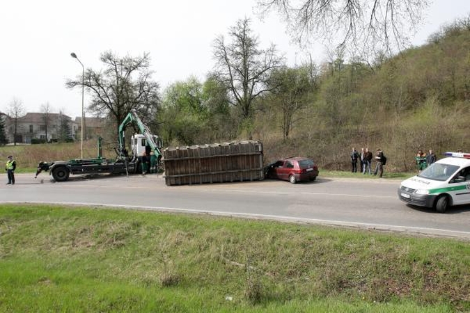 Konteineris užvirto ant pravažiuojančio automobilio